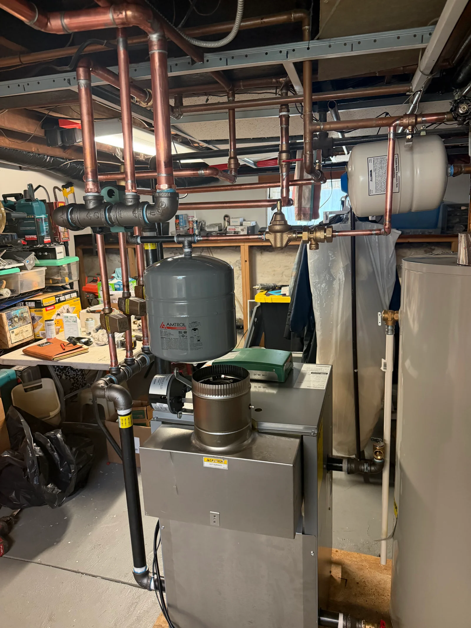 Boiler installation with copper and black iron piping, Amtrol and Watts expansion tanks, and brass circulator pumps in a basement